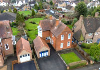 An aerial drone photo of a detatched house with large garden
